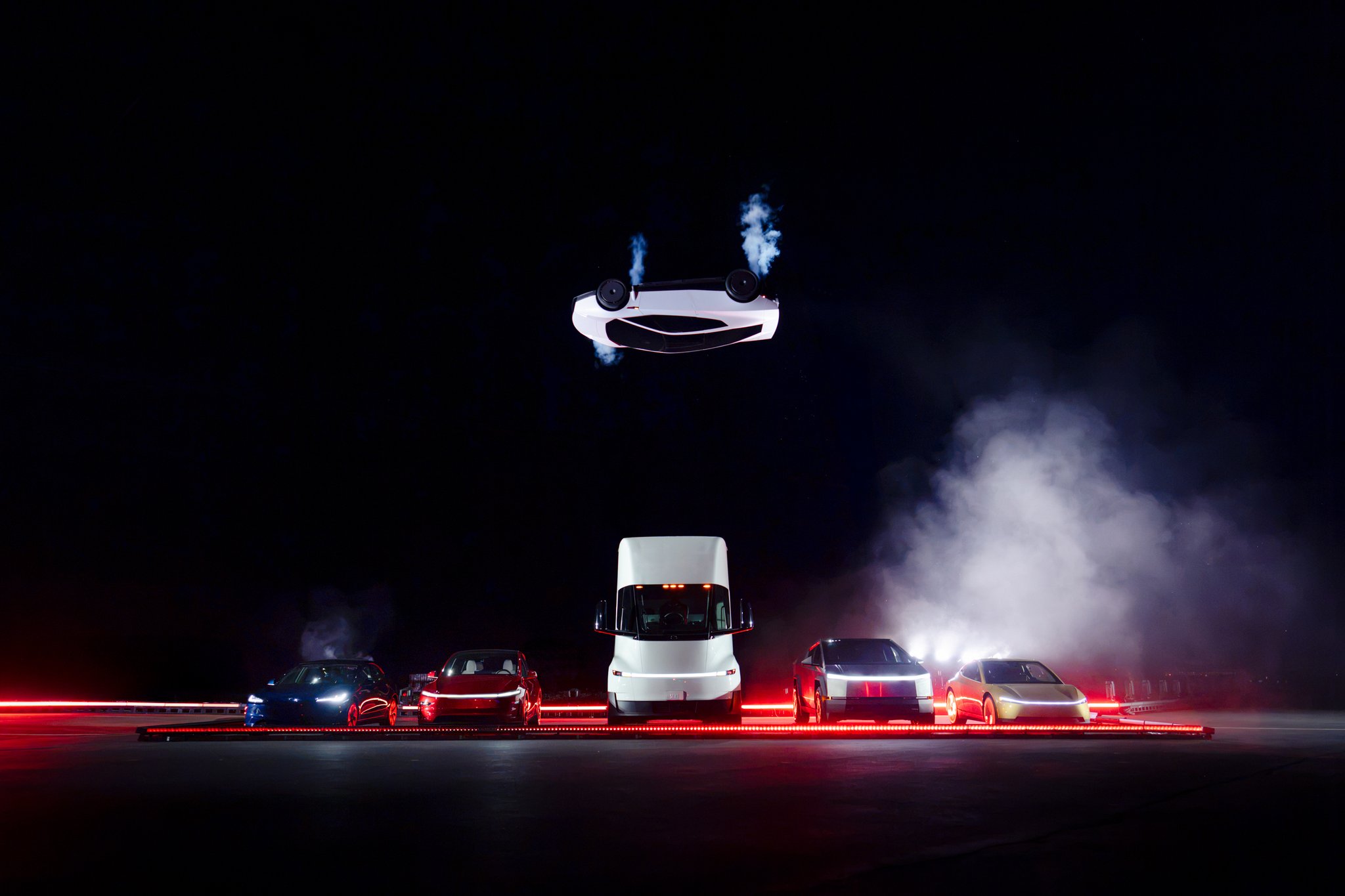 Tesla’s Roadster upside down above a row of other Tesla vehicles at the demonstration